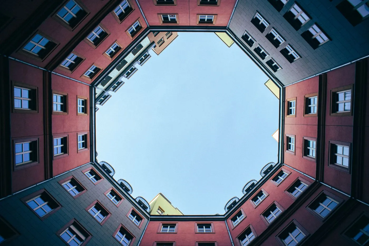 Bold red geometric architecture casting deep angular shadows