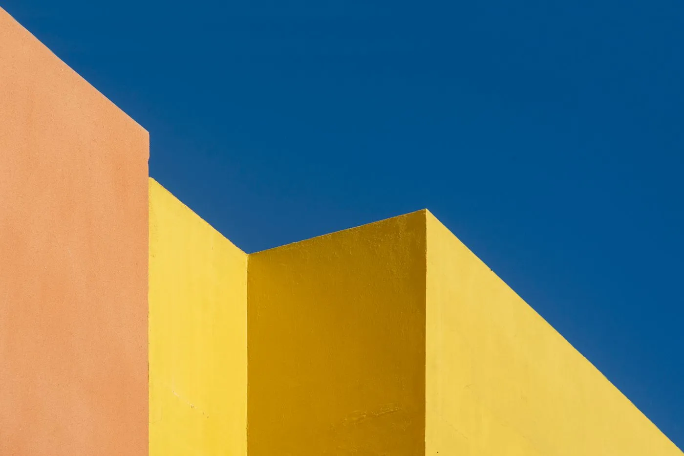Abstract blue facade with a bright yellow geometric opening